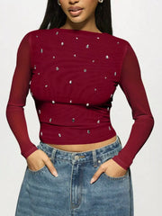 Woman wearing Rhinestone Embellished Long Sleeve T-Shirt with fitted silhouette and scattered rhinestones, paired with jeans.