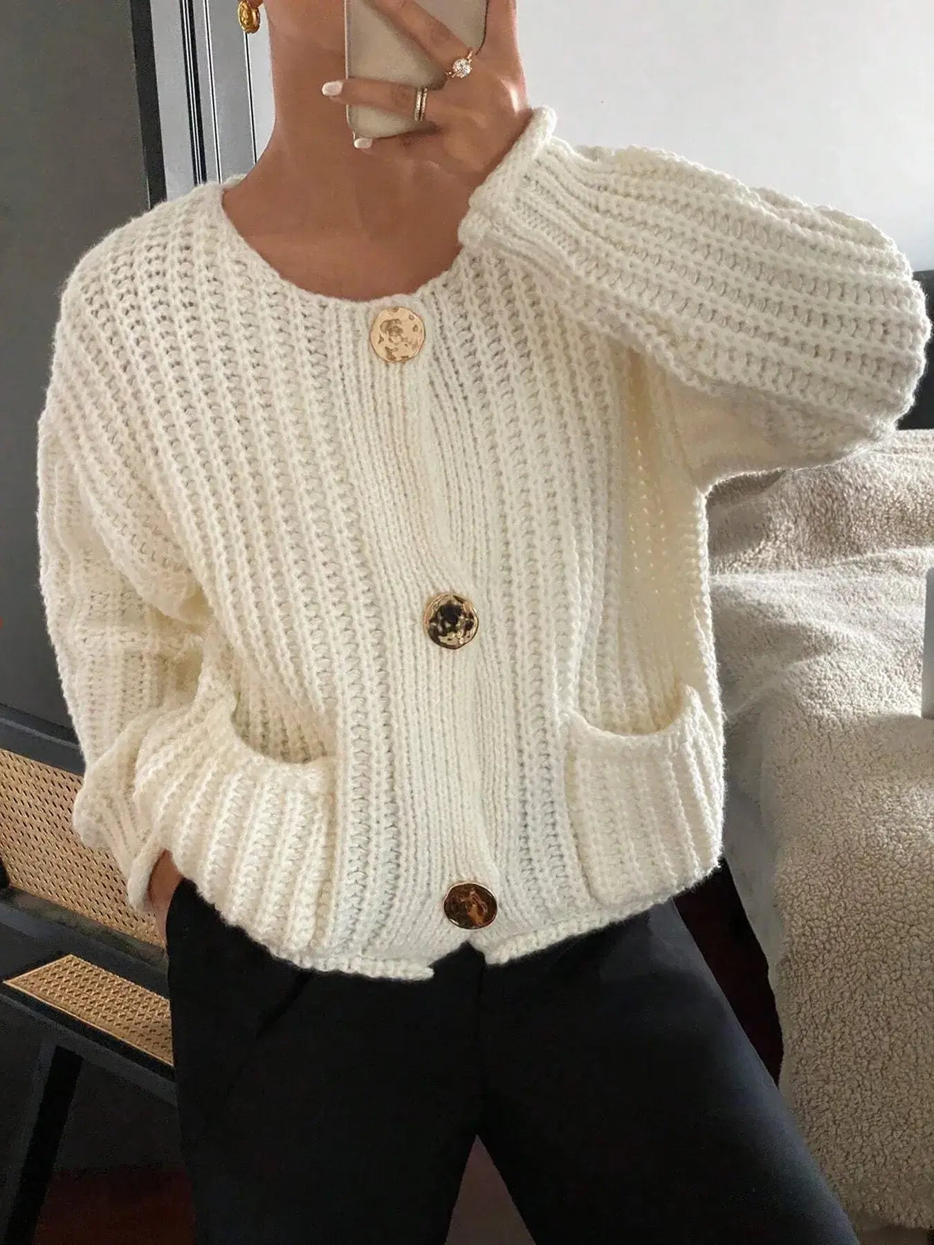 Woman wearing white button-front knit cardigan with pockets, perfect for cozy days or casual outings.