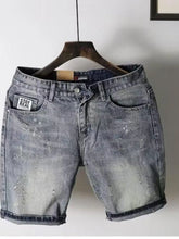 Men's pocketed denim shorts on a hanger, featuring a faded wash and slight distressing, ideal for casual wear.