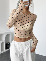 Model wearing Polka Dot Mesh Long Sleeve Crop Top paired with white trousers for a chic, modern look.