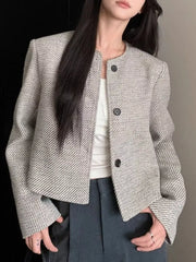Woman wearing Tweed Cropped Jacket with buttoned front, lined body, made of 100% polyester, suitable for machine wash. Fashionable outerwear.