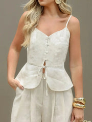 Lightweight cotton V-neck cami featuring button details and tie accents, styled with relaxed-fit pants for a chic loungewear look.