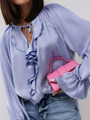 Woman wearing a Ruffle Trim Satin Flounce Sleeve Blouse with cascading ruffles, holding a pink purse