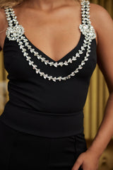 Layered crystal stone strap bodysuit, black, sleeveless, shimmering detail, sleek fit, polyester, elegant fashion piece.