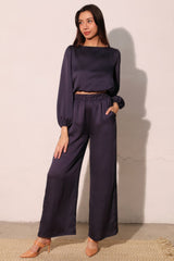 Woman wearing Modern Satin Pocket Pants in navy with matching top, showcasing hammered satin texture and relaxed silhouette.