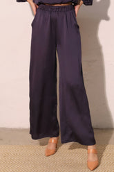 Model wearing Modern Satin Pocket Pants with lustrous hammered satin texture and functional pockets.