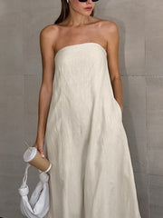 Model wearing a Smocked Back Tube Dress in cream color, showcasing a relaxed fit and strapless design.