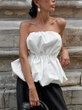 Woman wearing white Ruched Bubble Hem Tube Top against stone wall