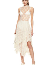 Model wearing ivory asymmetrical lace midi skirt with sheer floral design and partial lining.