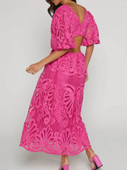 Woman wearing a pink cutout back lace crochet V-neck dress perfect for elegant occasions.