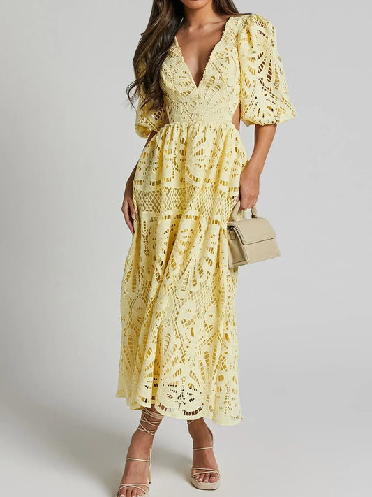 Woman wearing yellow cutout back lace crochet V-neck dress with puff sleeves, holding a handbag, perfect for evening soirées.