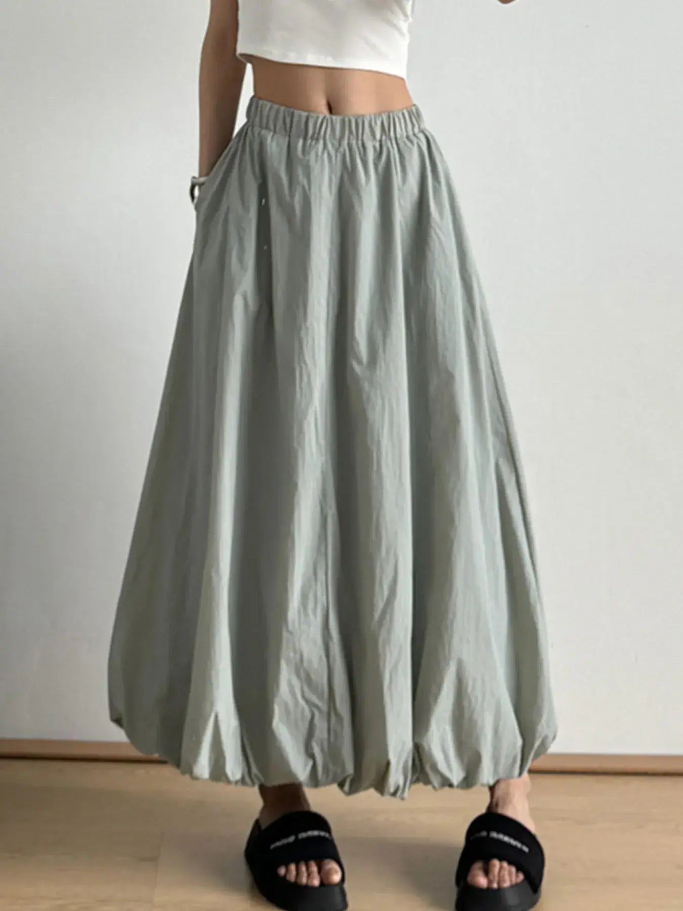 Green elastic waist bubble hem maxi skirt with paperbag waist and pockets shown on a model, perfect for casual and stylish looks.