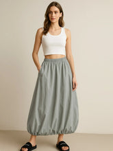 Model wearing a gray Elastic Waist Bubble Hem Maxi Skirt with paperbag waist and drawstring, styled with a white tank top.