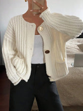 Woman wearing button-front knit cardigan with pockets in cream, styled for a casual chic look.