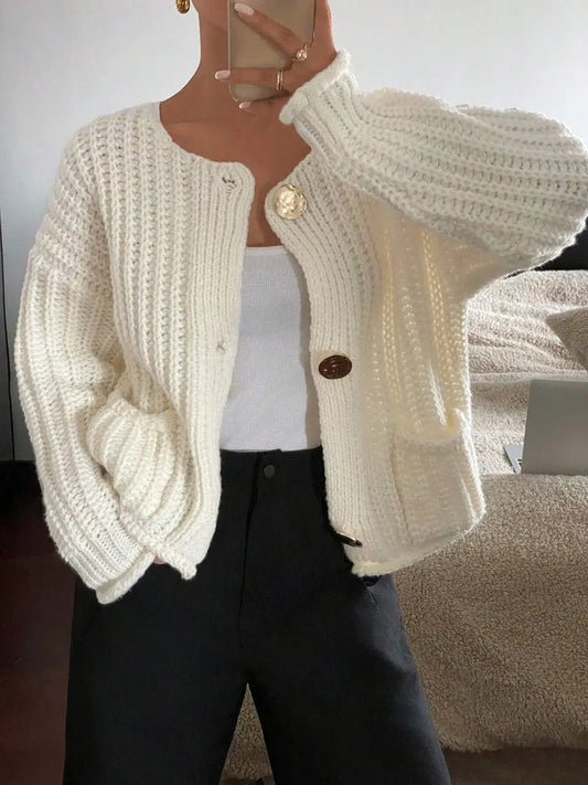 Woman wearing button-front knit cardigan with pockets in cream, styled for a casual chic look.