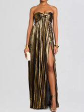 Woman wearing Split Sweetheart Neck Tube Maxi Dress with metallic fabric and thigh-high split, holding a clutch.
