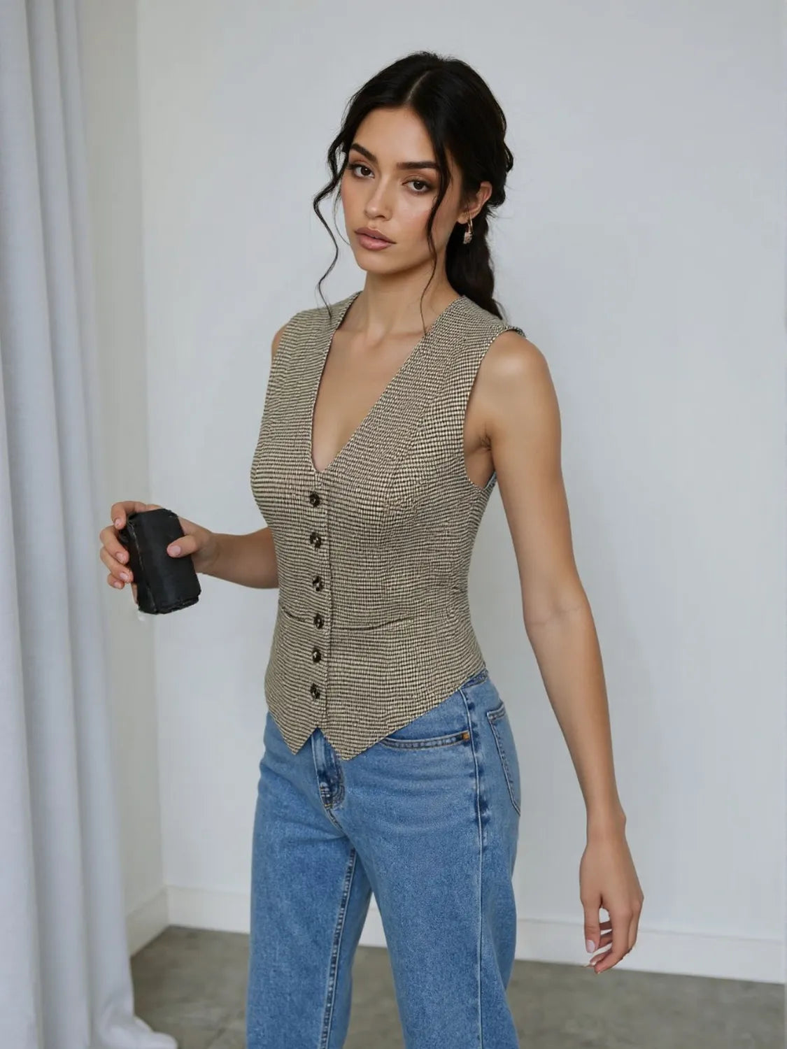 Model wearing a plaid button down vest with jeans, showcasing a clean, classic style and buttoned front design for everyday functionality.