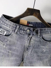 Men's pocketed denim shorts on a hanger, featuring buttoned and zipper closure with a lightly distressed wash.