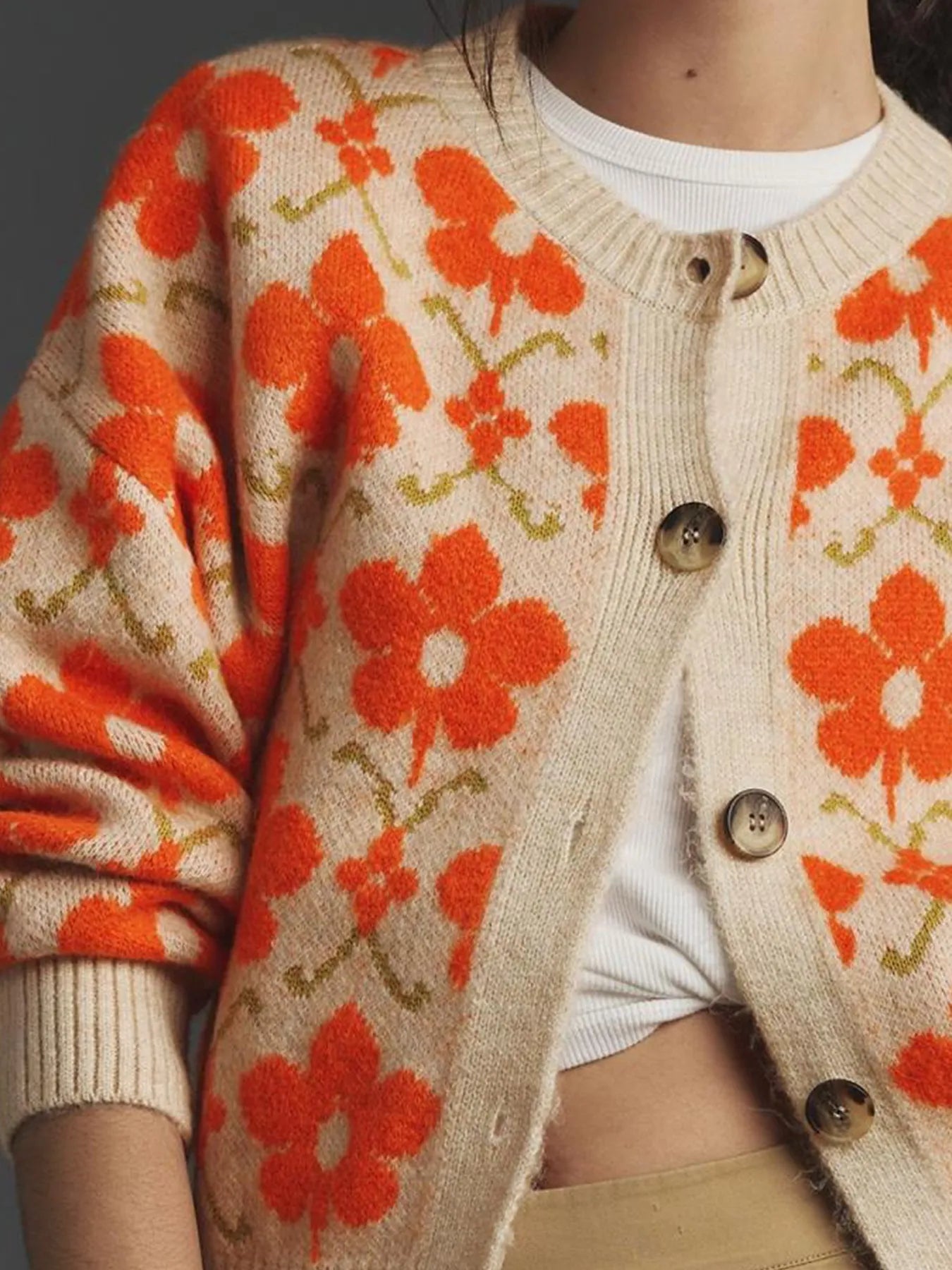 Model wearing a flower button up long sleeve cardigan with orange floral design, perfect for layering over tops.