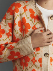 Close-up of floral button-up long sleeve cardigan with orange flower patterns and cozy knit design for stylish layering.