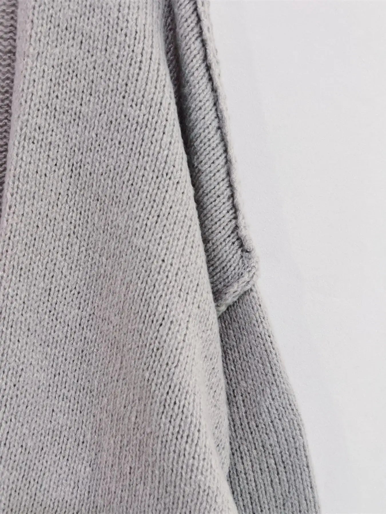 Close-up of grey oversized textured cardigan featuring soft-touch polyester material and dropped shoulder design.
