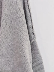 Close-up of grey oversized textured cardigan featuring soft-touch polyester material and dropped shoulder design.