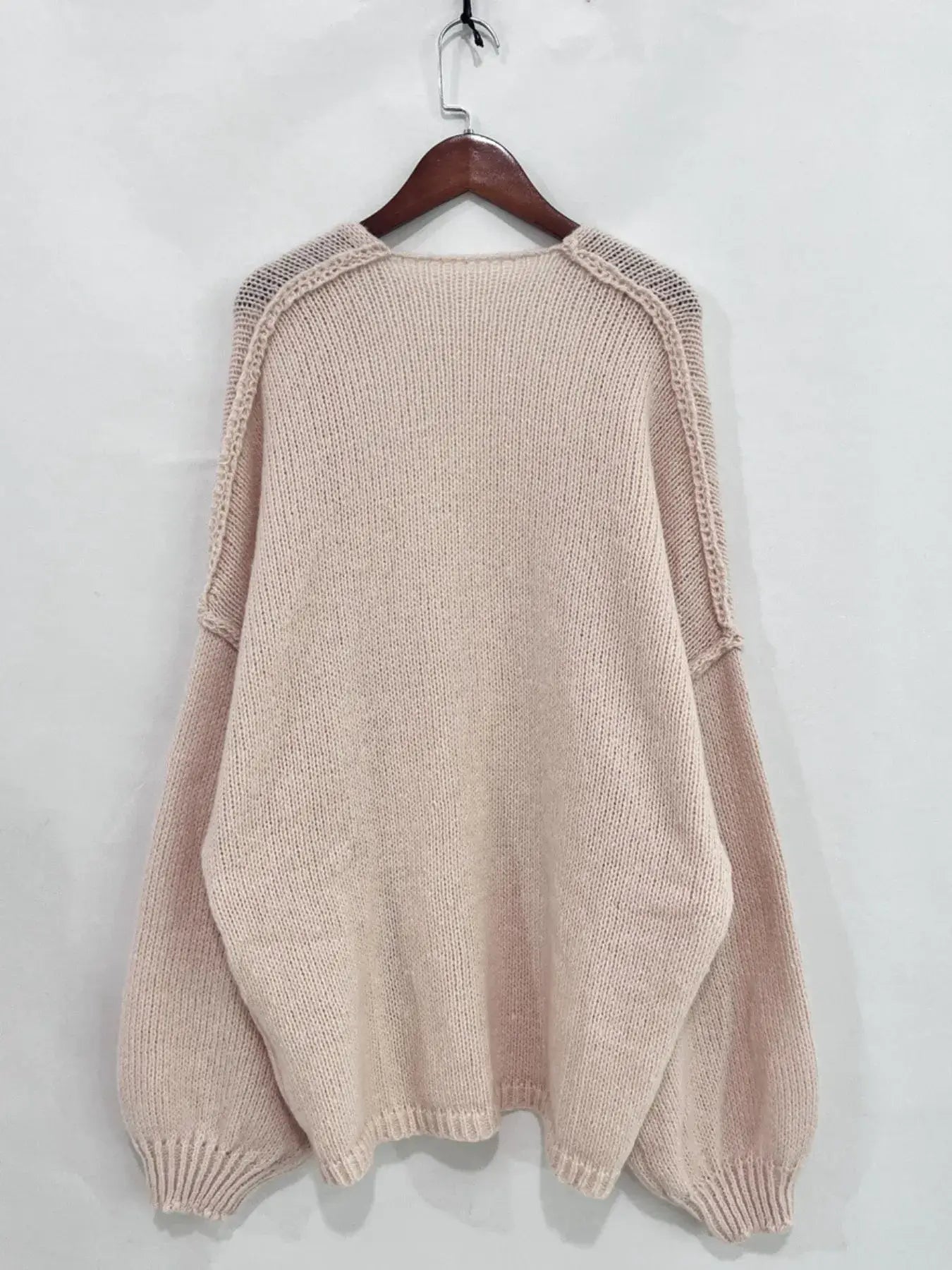 Back view of an oversized textured open front dropped shoulder cardigan in soft pink, showcasing its slouchy silhouette and luxe comfort.