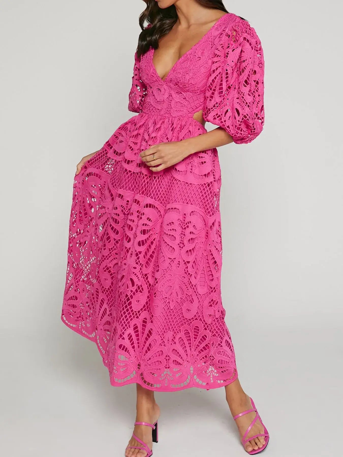 Woman wearing a vibrant pink cutout back lace crochet V-neck dress, featuring intricate lace detailing and puff sleeves, ideal for special occasions.
