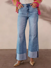 Distressed High-Waisted Flare Jeans worn with a colorful cardigan and stylish heels, highlighting the raw hem and slightly stretchy fit.