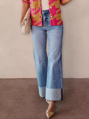 Model wearing Distressed High-Waisted Flare Jeans with a colorful cardigan and stylish accessories.