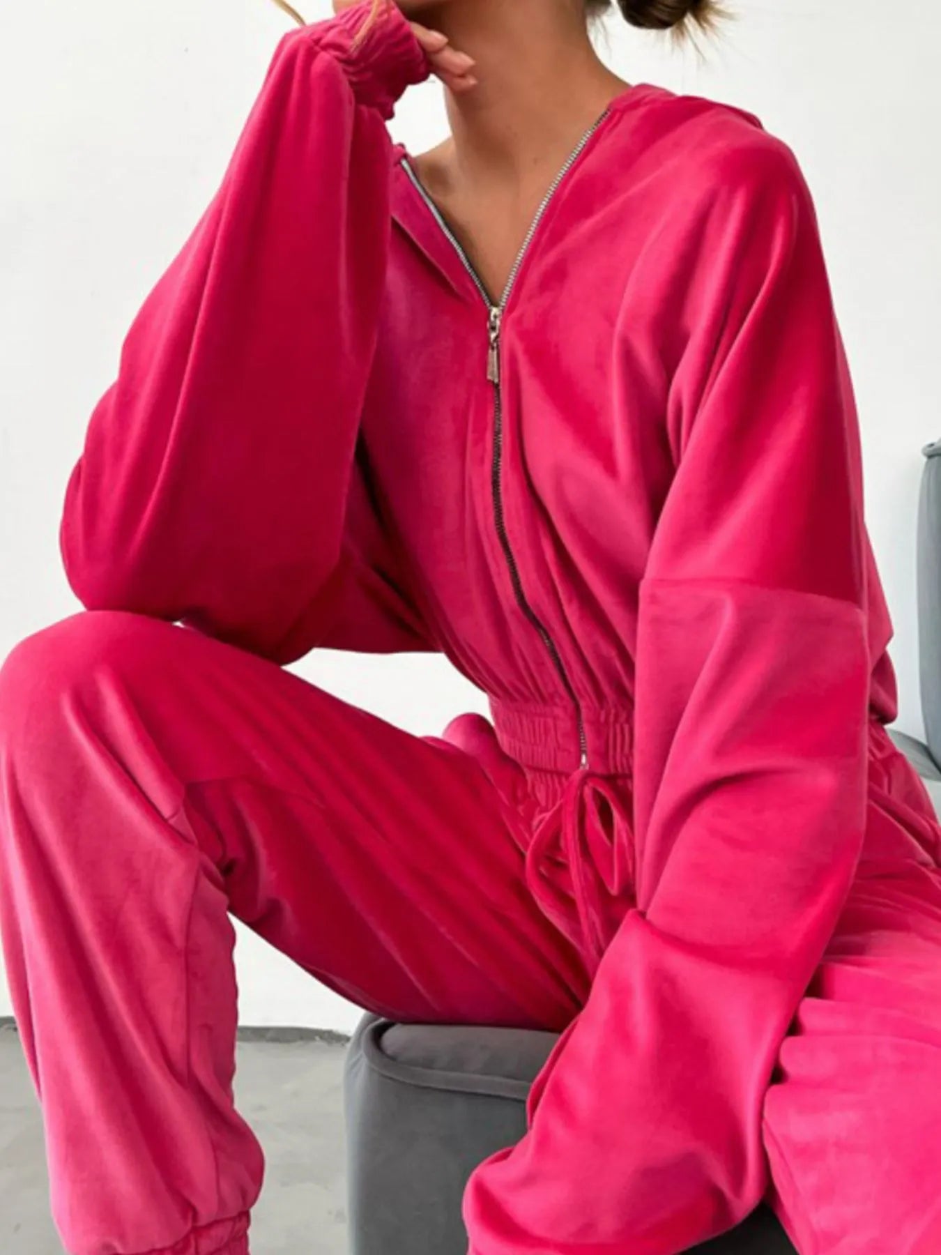 Women wearing plush pink zip-up long sleeve top and pants set, featuring a relaxed fit and matching joggers with drawstring waist.