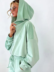 Woman wearing sky blue zip up long sleeve top and pants, showcasing a plush velour lounge set with hoodie and drawstring joggers.