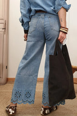 Woman wearing lace detail cropped wide leg jeans and a black tote bag, showcasing a stylish back view.