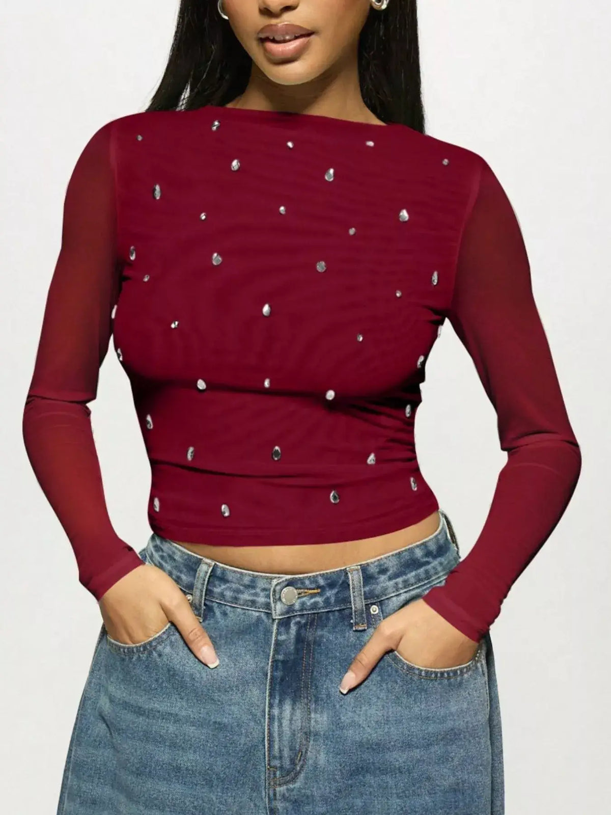 Woman wearing Rhinestone Embellished Long Sleeve T-Shirt with fitted silhouette and scattered rhinestones, paired with jeans.