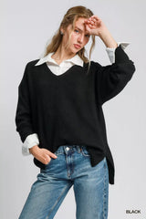 Woman wearing Umgee Wool Blended Pullover Sweater in black, oversized V-neck design, styled over a white shirt, emphasizing comfort and elegance.