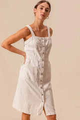 Side angle of SO ME pinafore dress highlighting button down front, square neckline, and pocket details.