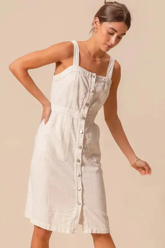 Model in SO ME pinafore dress with button front and wide straps, showcasing a flattering fit and casual style.
