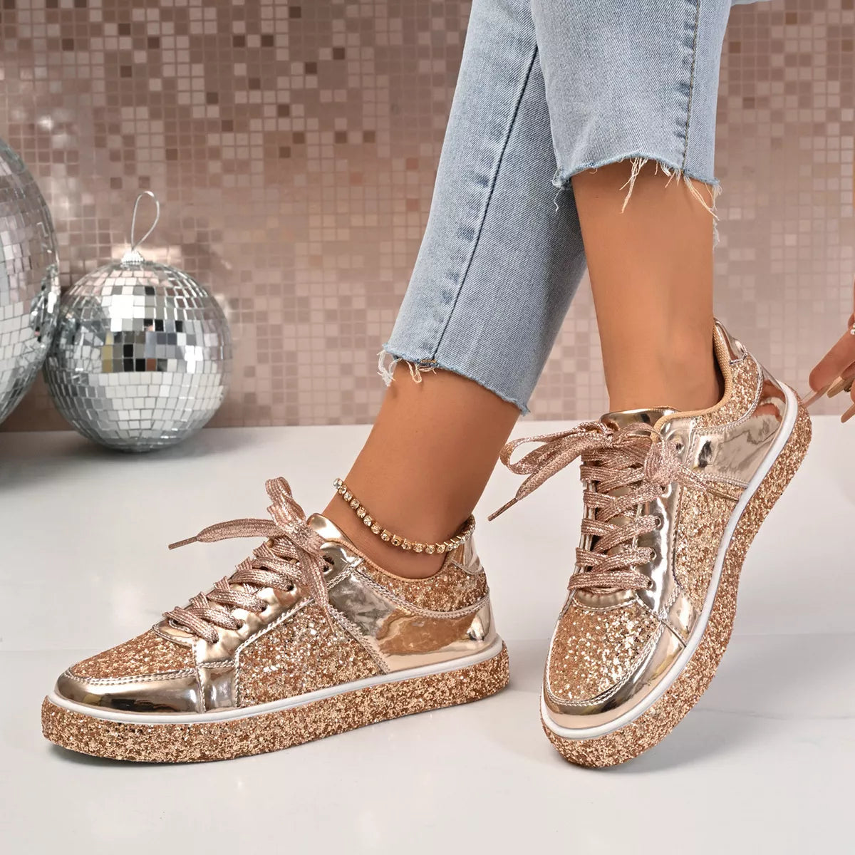 Sequin Lace Up Sneakers with PU leather and rubber sole, shown in stylish gold, worn with blue jeans, disco balls in the background.