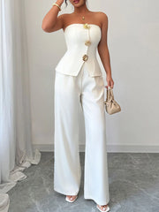 Woman wearing a stylish white tube top and wide-leg pants set, accessorized with a small handbag; perfect for casual or formal events.