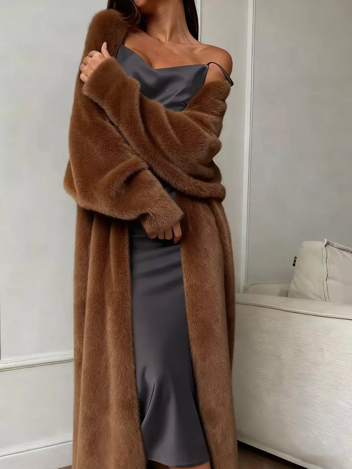 Woman wearing a Fuzzy Open Front Longline Cardigan over a dress, showcasing a relaxed fit and plush texture, suitable for layering.