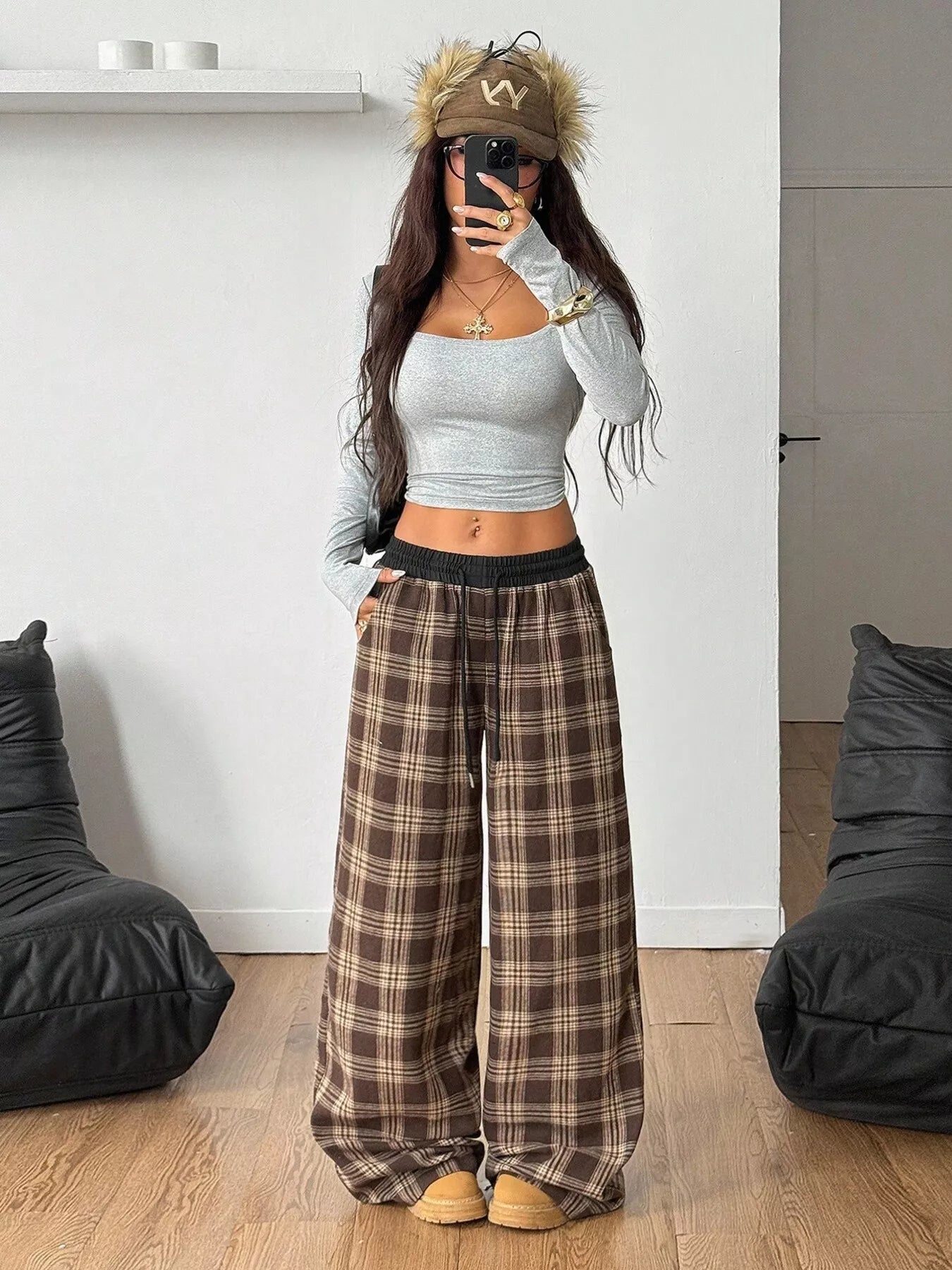 Girl wearing GirlSavvi’s Plaid Wide Leg Pants with a gray top, featuring a relaxed fit and drawstring waist, in a stylish room setting.