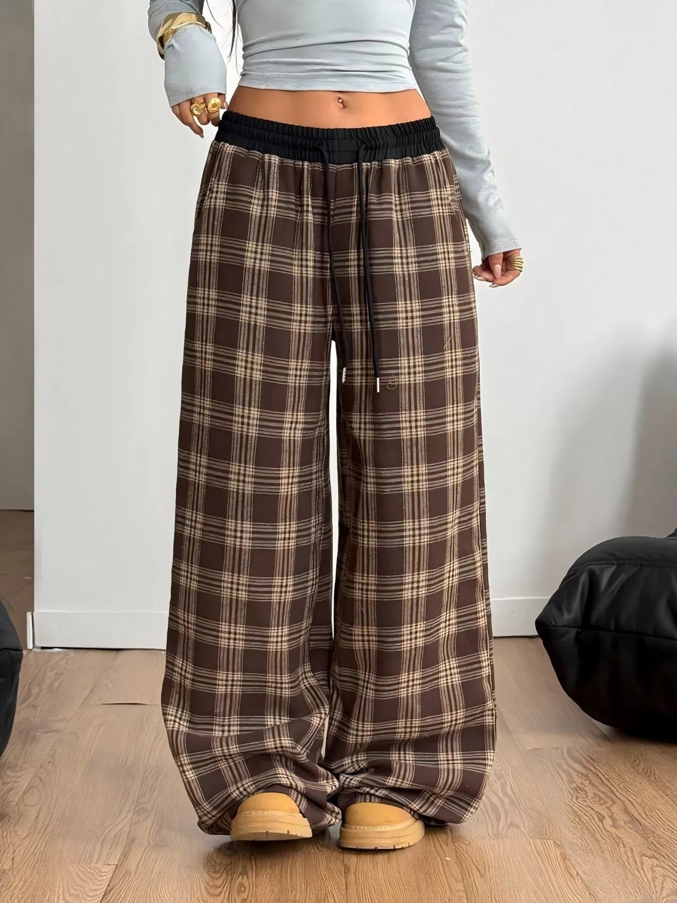 Woman wearing GirlSavvi’s Plaid Wide Leg Pants with adjustable drawstring, relaxed fit, and functional pockets for versatile styling.