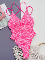 Flat lay of pink Leopard Plunge Swimwear, showcasing plunge neckline, stretchy fabric, and vibrant leopard print.