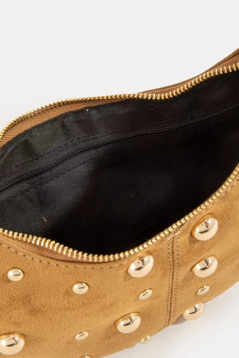 Interior view of the Fame Dome Studded Chrome Crescent Hand Bag with gold studs and black lining