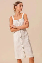 Model wearing button down pinafore dress with wide straps and front patch pockets, ideal for casual outfits.