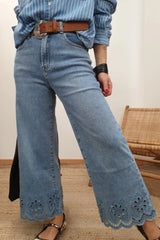 Lace detail cropped wide leg jeans featuring openwork design, styled with a striped shirt and belt.