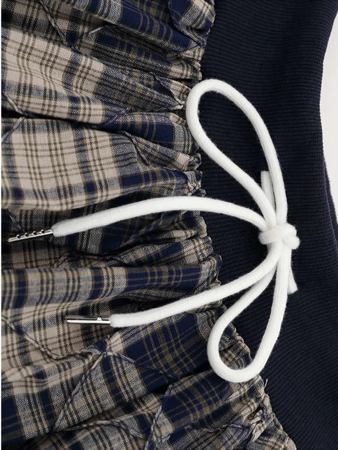 Close-up of ruched drawstring on plaid skort, showcasing the classic design of the Drawstring Plaid Skort with adjustable detail.