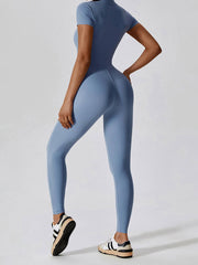 Back view of blue Basic Bae Half Zip Short Sleeve Active Jumpsuit highlighting contoured fit and seamless activewear style.