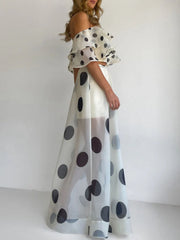 Woman wearing Polka Dot Ruffle Crop Top and Maxi Skirt Set, showcasing an elegant off-shoulder design and bold polka dot pattern.