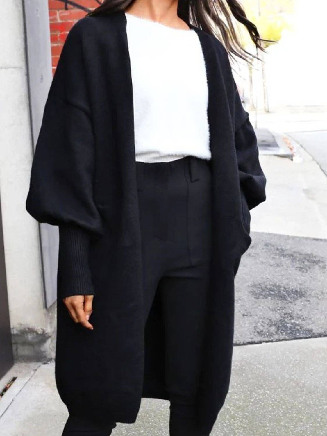 Black Perfee Open Front Dropped Shoulder Cardigan styled with monochrome outfit, highlighting its oversized sleeves and open front design.